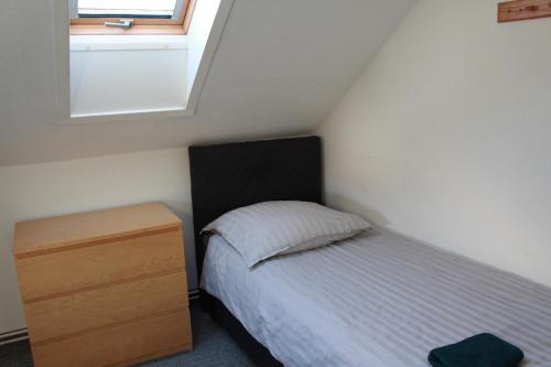 a bedroom with a bed and a dresser and a window at Rana's Zimmervermittlung in Bremen