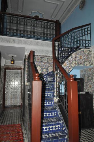 a staircase in a house with blue and white tiles at Riad Khouloud in Fès
