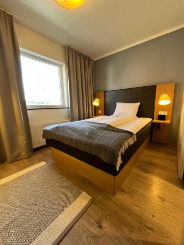 a bedroom with a bed and a large window at Granavolden Hotel & Gjæstgiveri in Gran