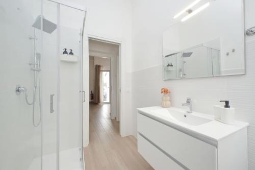 a white bathroom with a sink and a shower at Elegante e Comodo - A pochi minuti dall'Aeroporto in Fiumicino