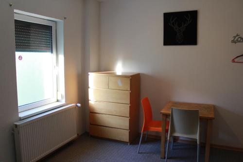 a room with a desk and a table and a dresser at Rana's Zimmervermittlung in Bremen