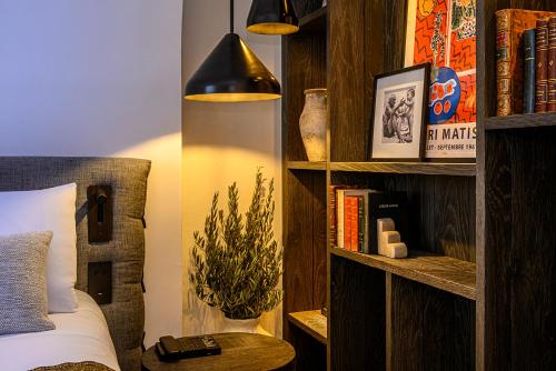 a bedroom with a bed and a book shelf at L'Isle de Leos Hotel & Spa - MGallery Collection in LʼIsle-sur-la-Sorgue
