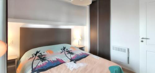 - une chambre avec un lit et une couverture colorée avec des palmiers dans l'établissement Appartement confortable à Remoulins, 49 m² avec piscine, à Remoulins