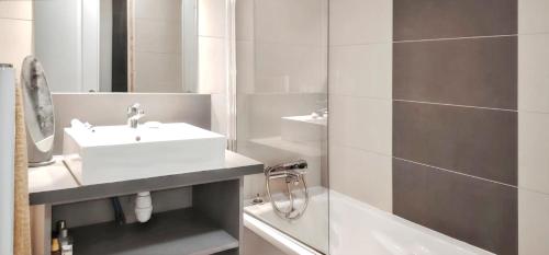une salle de bain blanche avec un lavabo et une douche dans l'établissement Appartement confortable à Remoulins, 49 m² avec piscine, à Remoulins