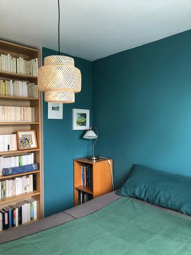 - une chambre dotée d'un mur bleu avec un lit et une lampe dans l'établissement Trouz An Dour, à Fouesnant
