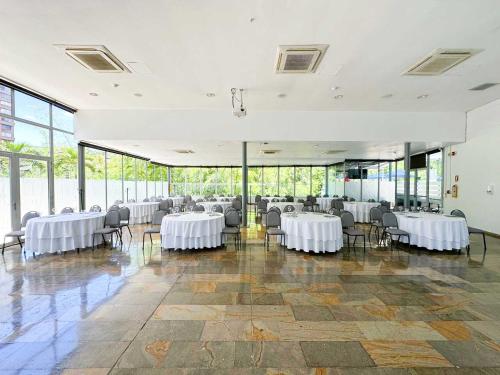 a banquet hall with white tables and chairs at Hotel San Fernando Plaza in Medellín