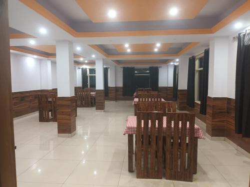 a room with wooden chairs and tables in it at Hotel Royal Place in Rāmpur
