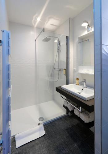 a bathroom with a shower and a sink at Les Maisons du Pont - Charme & Caractère in Aubusson