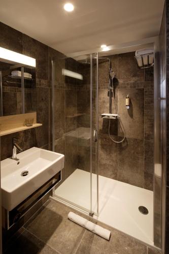 a bathroom with a shower and a sink and a shower at Les Maisons du Pont - Charme & Caractère in Aubusson