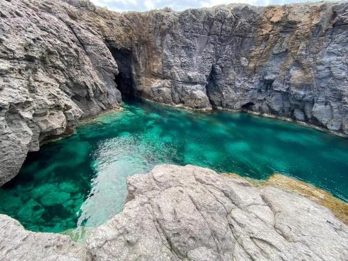 an aerial view of a body of water in a rocky cliff at Il Paradiso è qui in SantʼAntìoco