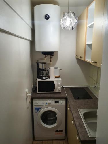 een keuken met een magnetron en een wasmachine bij ChicStudio feel at home in Galaţi