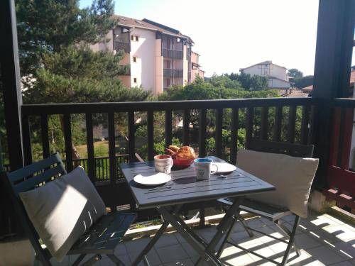 - une table sur un balcon avec un bol de nourriture dans l'établissement Ambiance Cosy Capbreton, à Capbreton