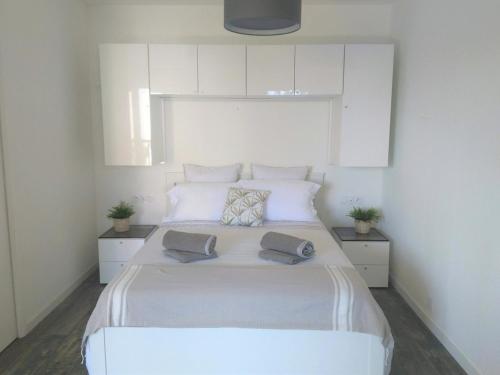 Cette chambre comprend un grand lit blanc et des armoires blanches. dans l'établissement Ambiance Cosy Capbreton, à Capbreton