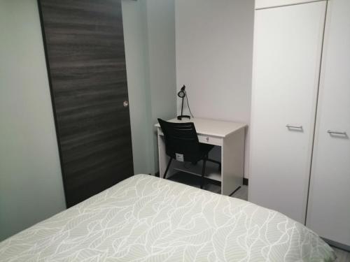 - une chambre avec un bureau, un lit, un bureau et une chaise dans l'établissement Appartement tout proche de Bourg-en-Bresse, à Péronnas