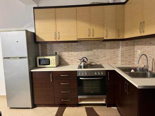 a kitchen with a white refrigerator and a sink at Saranda Spot Apartment in Sarandë