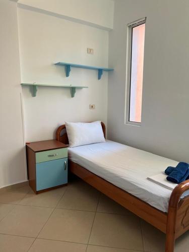 a small bedroom with a bed and a window at Saranda Spot Apartment in Sarandë