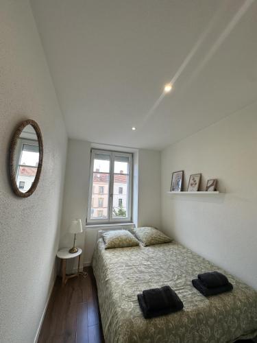 une chambre avec un lit, un miroir et une fenêtre dans l'établissement # Le 3 # Joli appartement T3 Mulhouse centre, Neuf, calme et tout équipé, à Mulhouse