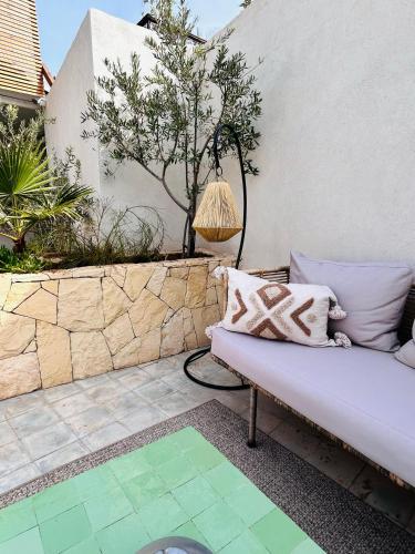 a couch sitting on a patio next to a wall at Riad Villa Wengé & Spa in Marrakech
