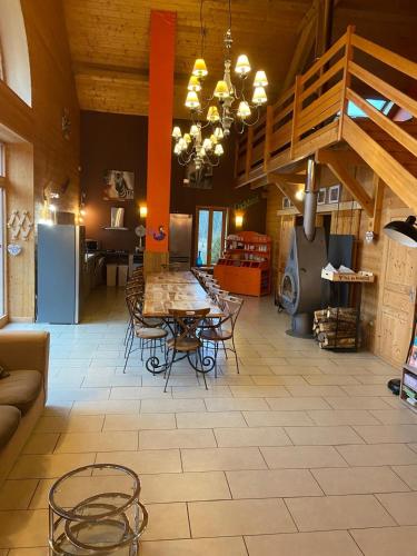 un salon avec une table et des chaises dans une pièce dans l'établissement Le MARLAYA PROCHE DU LAC DE VOUGLANS, à Charchilla