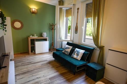 a living room with a couch and two windows at 5 mins to the beach, cozy home in Rapallo