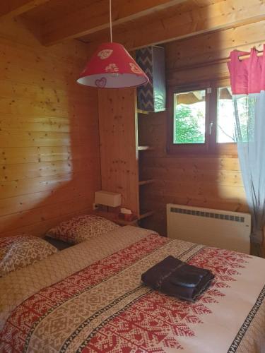 une chambre avec un lit et une lampe rouge dans l'établissement Le Chalux, à La Bresse