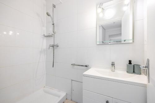 une salle de bain blanche avec un lavabo et une douche dans l'établissement L’Écrin Franklin - Proche Château de Versailles, à Versailles