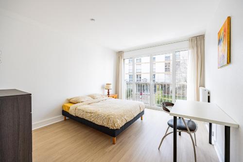 une chambre avec un lit, un bureau et une fenêtre dans l'établissement L’Écrin Franklin - Proche Château de Versailles, à Versailles