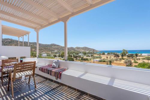 a balcony with a table and chairs and a view of the ocean at Mylopota apartment IIΙ in Mylopotas