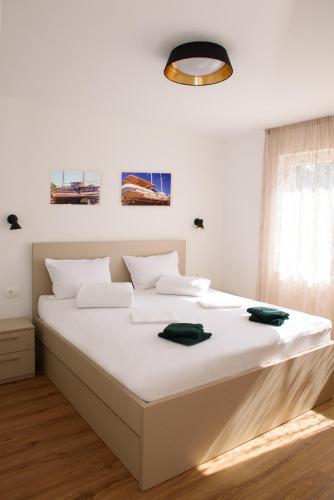a white bedroom with a large bed with white sheets at Villa Mária Marta in Mirce