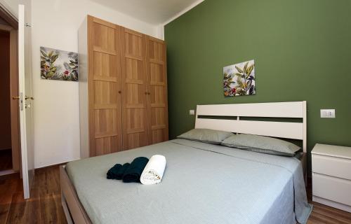 a bedroom with a bed with a green wall at 5 mins to the beach, cozy home in Rapallo