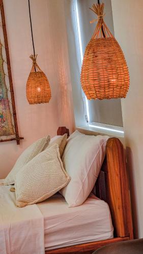 a room with a bed with two lamps and a window at Flat Vila Maria in Marechal Deodoro