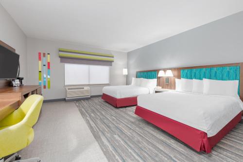 a hotel room with two beds and a flat screen tv at Hampton Inn and Suites Lake Jackson-Clute in Clute