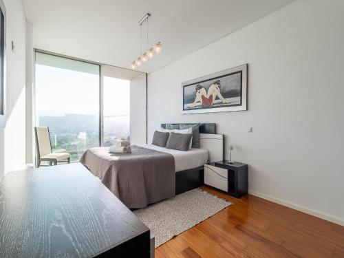 a bedroom with a bed and a large window at Akivillas Sintra Stone in Sintra