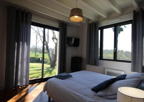 une chambre avec un lit et une grande fenêtre dans l'établissement Gite de FRIZOT, 5 minutes de Nogaro, all inclusiv, à Sion