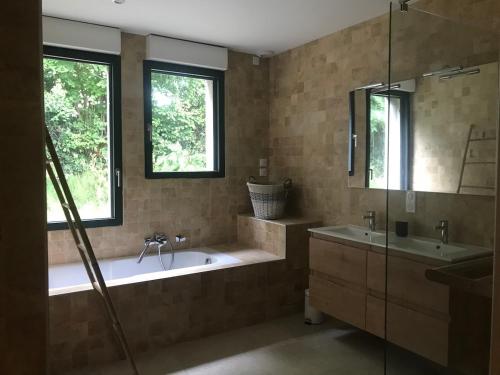 une salle de bain avec une baignoire et un lavabo dans l'établissement Gite de FRIZOT, 5 minutes de Nogaro, all inclusiv, à Sion