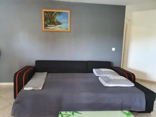 a bed with two pillows on it in a room at Les Hauts de Beline Petit-Havre in Le Gosier