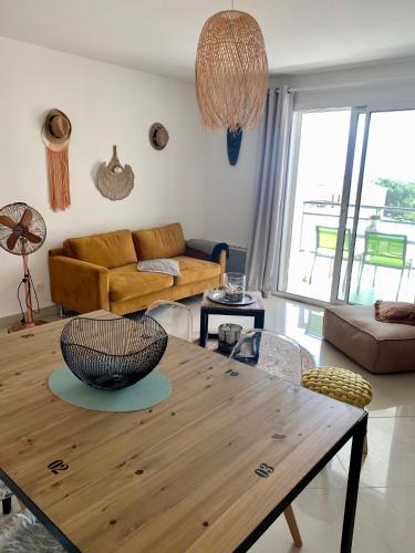 un salon avec une table en bois et un canapé dans l'établissement T3 cosy - grande terrasse en accès direct à la mer, à Fleury