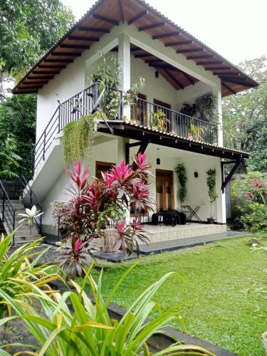 a house with a balcony and a yard at Kithmi Resort in Polonnaruwa