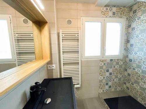 une salle de bain avec un lavabo et deux fenêtres et une baignoire dans l'établissement Spacieux T2 au bord de l'eau, vue panoramique, à Six-Fours-les-Plages