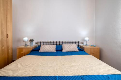 a bedroom with a blue bed with two night stands at Appartamento Cerri in Badesi
