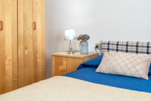 a bedroom with a bed and a table with a lamp at Appartamento Cerri in Badesi