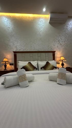 a large bed with white pillows and two lamps at IDGA appartement with panoramic view in Chefchaouene