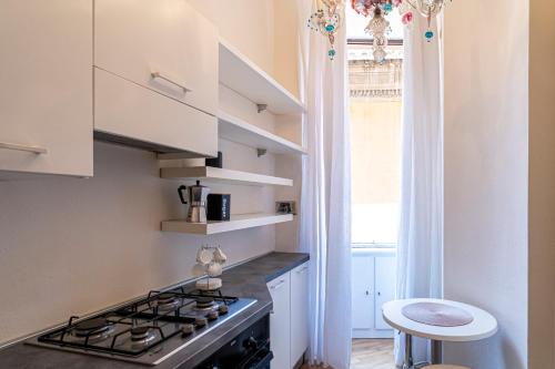 uma cozinha com fogão forno superior ao lado de uma janela em Margana Luxury 3 bedrooms amazing terrace em Roma