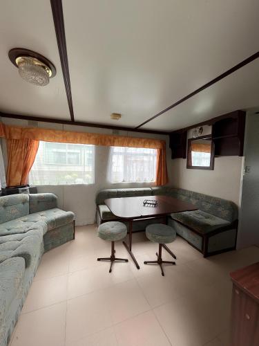 un salon avec une table, des chaises et un canapé dans l'établissement Mobil Home Saint Jacut De La Mer, à Saint-Jacut-de-la-Mer