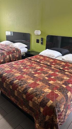 a hotel room with two beds and a quilt at Fort Myers Inn in Fort Myers