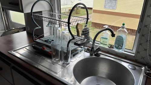 a kitchen sink with a drying rack next to a sink at Mobil Home Saint Jacut De La Mer in Saint-Jacut-de-la-Mer