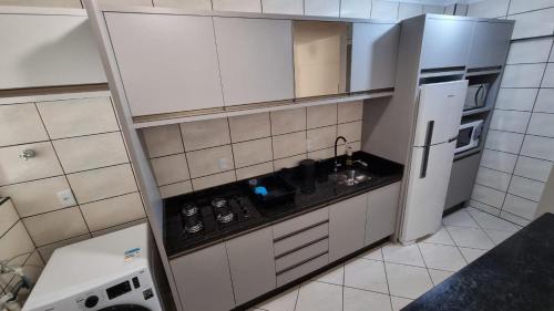 Dapur atau dapur kecil di Apartamento pé na areia em Meia Praia com churrasqueira com vista mar