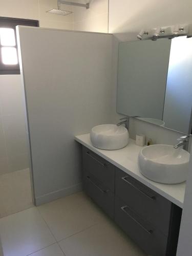 une salle de bain avec deux lavabos et un miroir dans l'établissement Pura Vida, à Lège-Cap-Ferret