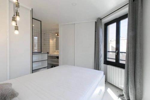 une chambre blanche avec un lit et une fenêtre dans l'établissement Bel appartement central confortable 2-3 personnes, à Paris