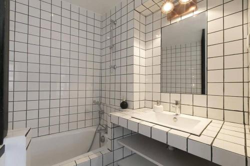 une salle de bain avec un lavabo, une baignoire et un miroir dans l'établissement Bel appartement central confortable 2-3 personnes, à Paris